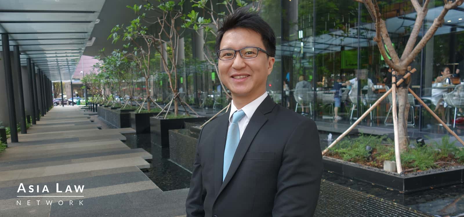 an image of Singapore lawyer Lau Kah Hee with a picturesque hotel in the background