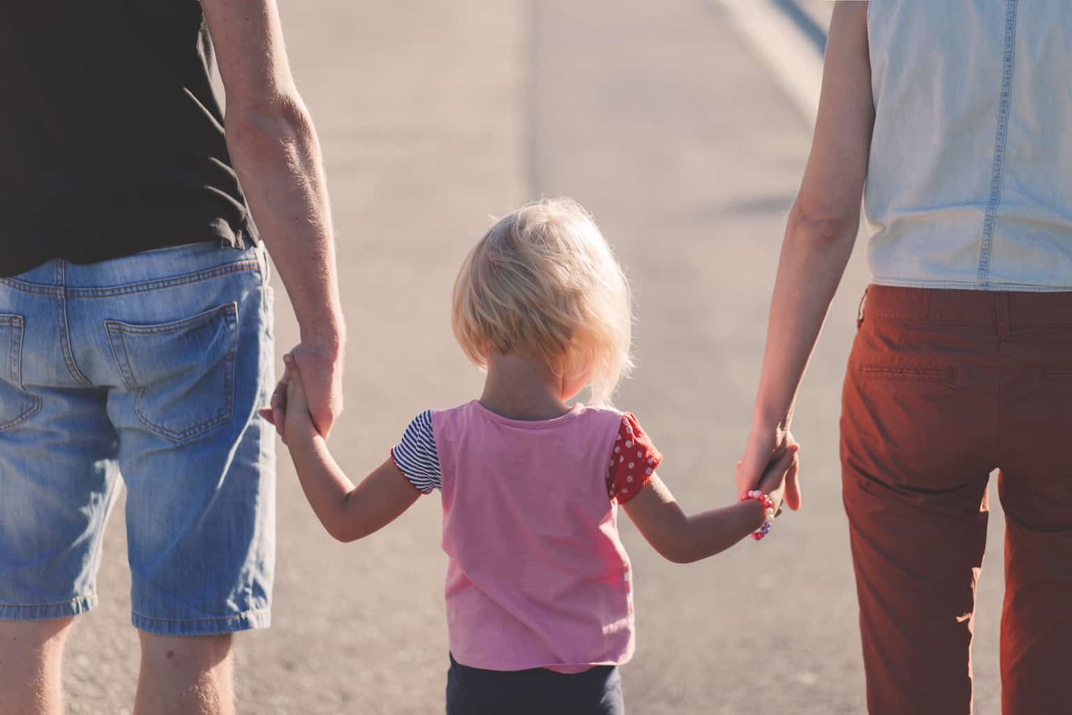 Hague convention -- backview of a couple holding hands with a child in the middle