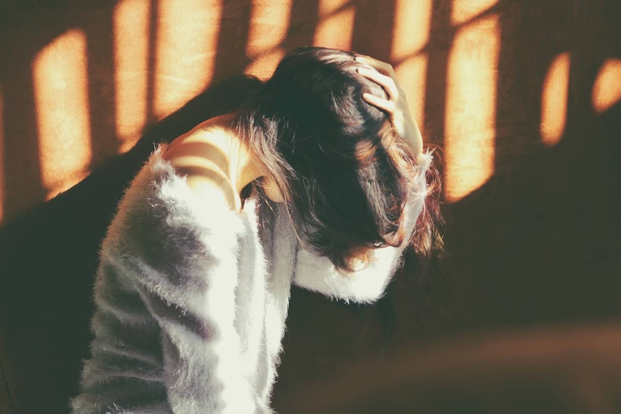a female with her head down, covered by her hair (divorce_proceedings_singapore)