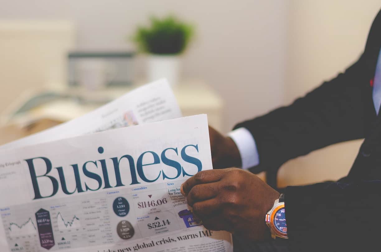 Man holding a business newspaper (securities_&_futures_act_asia_law_network)