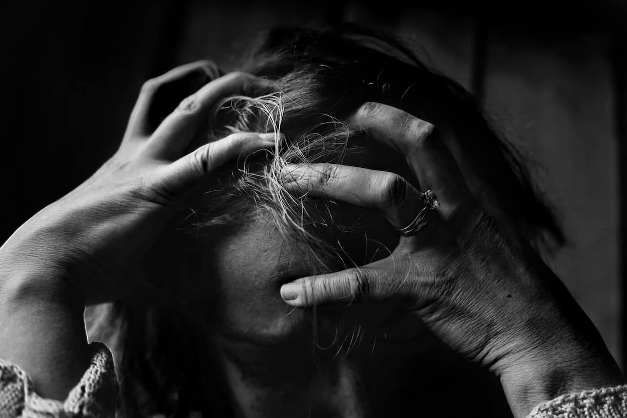 black and white photo of a woman holding her hand to her head (women's_charter_divorce_maintenance)