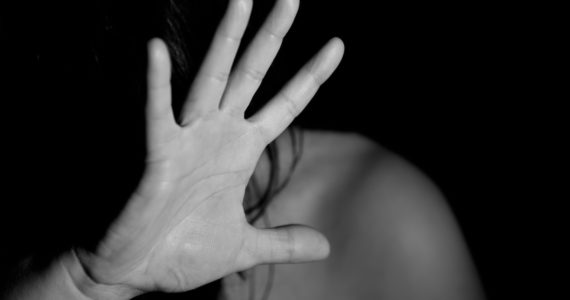 black and white photo of a woman shunning away while raising her hand (Personal_protection_orders_Asia_Law_Network)
