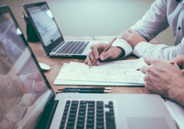 two laptops with pens and paper in between (business_structure_asia_law_network)