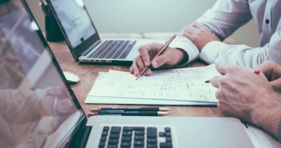 two laptops with pens and paper in between (business_structure_asia_law_network)