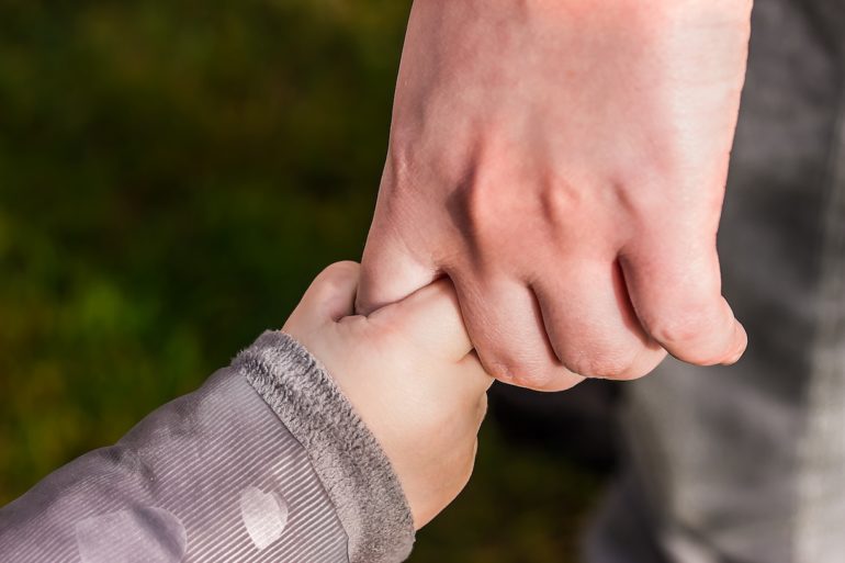 a child hand holding an adult hand (custody_care_control_children_divorce_asia_law_network)