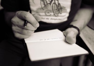 a person holding a pen and writing on a notebook (mental_capacity_act_asia_law_network)