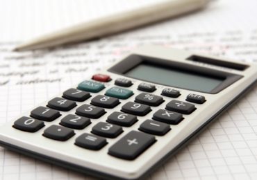 A calculator and pen on a piece of grid-lined paper (Tax Deductions for Costs relating to Intellectual Property_Asia_Law_Network)