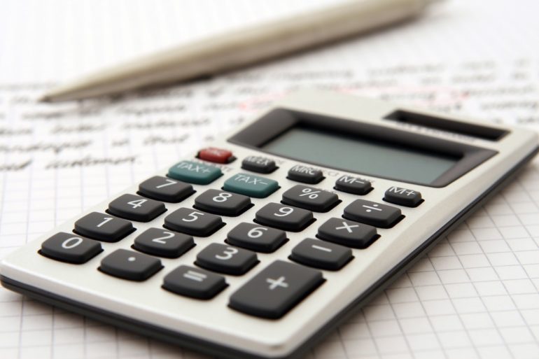 A calculator and pen on a piece of grid-lined paper (Tax Deductions for Costs relating to Intellectual Property_Asia_Law_Network)